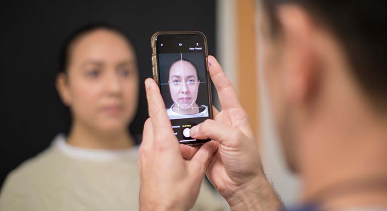 Man taking a picture of woman’s face with a phone